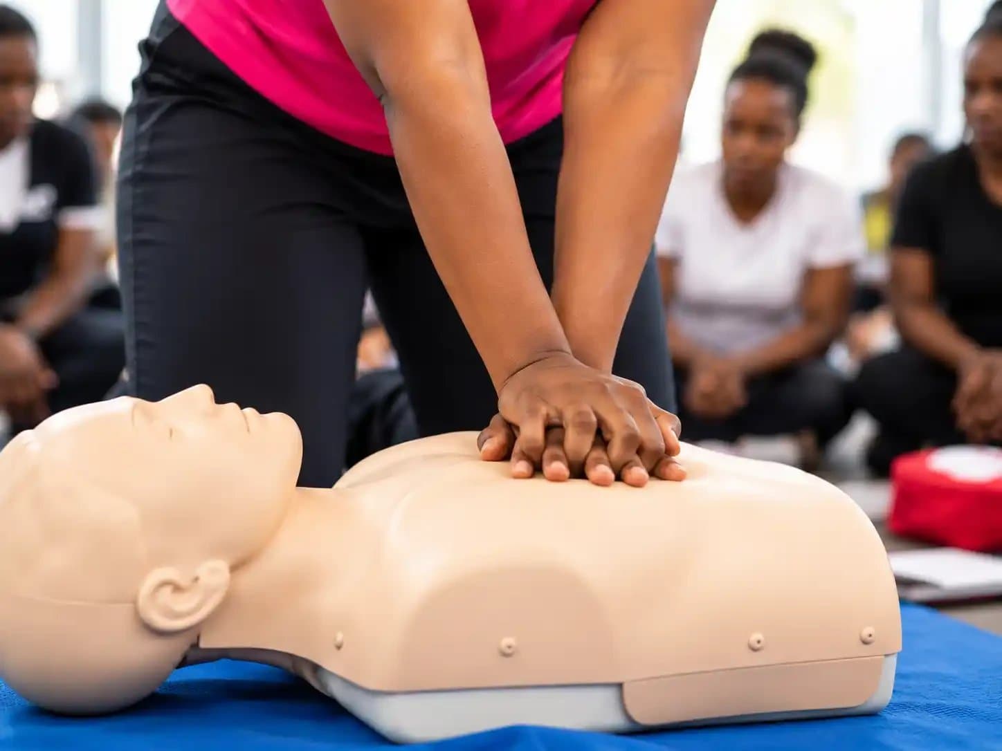 Close up of hands performing chest compressions on a CPR manikin